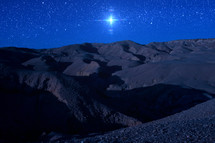 bright star over a desert landscape at night 