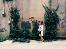 pregnant woman in front of a graffiti covered wall 