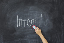 erasing the word Integrity off of a chalkboard 