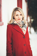 portrait of a smiling woman in a red peacoat 
