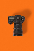 camera against an orange background 