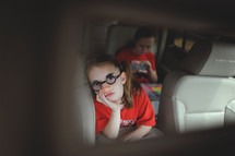 children riding in the backseat of a car 