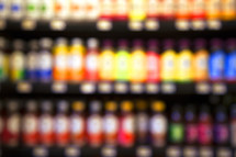blurry image of juice bottles on a store shelf 