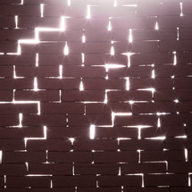 light through the cracks on a brick wall 