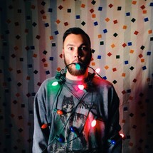 man wrapped in Christmas lights 