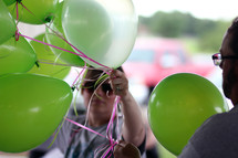 woman with green helium balloons