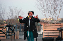 woman singing into a microphone outdoors 