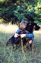 a little boy hugging his dog 