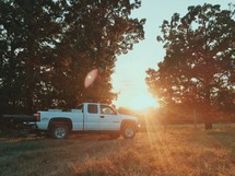 a truck parked in a field and sunburst 