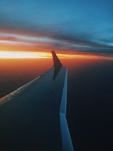 wing of a plane in a sky at sunset 