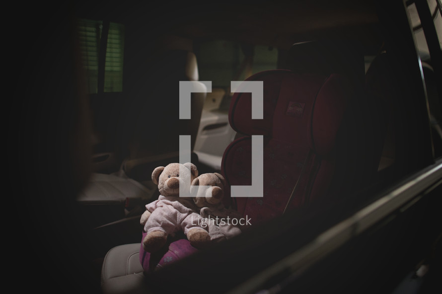 teddy bears in a carseat 