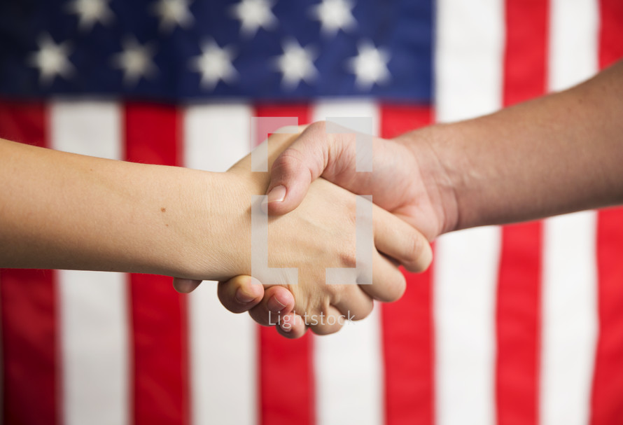 A handshake in front of an American flag.