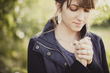 woman with her hands folded in prayer