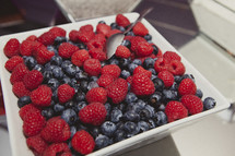 A bowl full of blueberries and raspberries