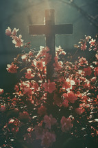 Cross and spring flowers in the field. Retro style toned image