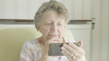 Senior caucasian woman using a smartphone themes of retired pensioner technology wifi