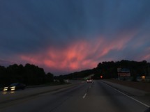 pink skies at sunset above a highway 