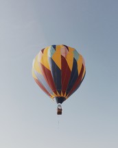 A colorful hot air balloon floating in the sky.