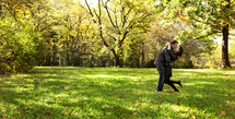 Husband and wife kissing in open grass field