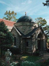 a stone chapel and a statue of St Francis 