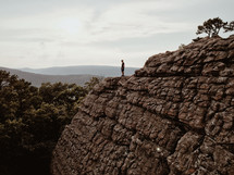 a man standing at the edge of a steep cliff 