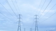 Timelapse of electricity pylons against a stormy sky themes of electricity power energy