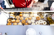 Donut frying in a vat of oil.
