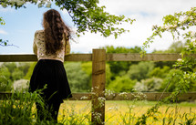 a teen girl looking over a fence