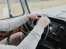 hands on a steering wheel of a VW van 