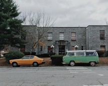 older model vehicles, parked on the side of a road 