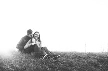 a couple sitting in grass outdoors 