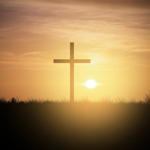 Christian cross at sunset sky