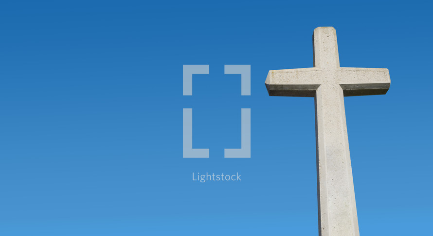 stone cross against a blue sky 