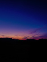 silhouette of hills and pink sky at sunset 