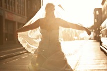 bride holding her vail out in the sunlight