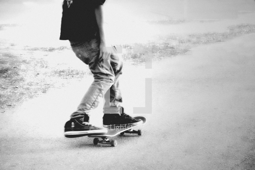 black and white photo of a teen on skateboard