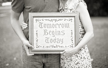 couple holding a framed picture - Tomorrow Begins Today