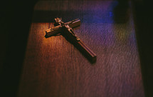 Crucifix sitting in colored light on a pew in a Roman Catholic church