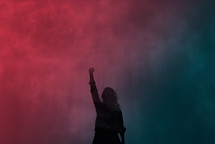 silhouette of a woman against a smoky pink and blue background 