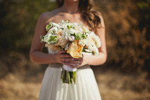 A bridesmaid holds a bouquet of flowers.