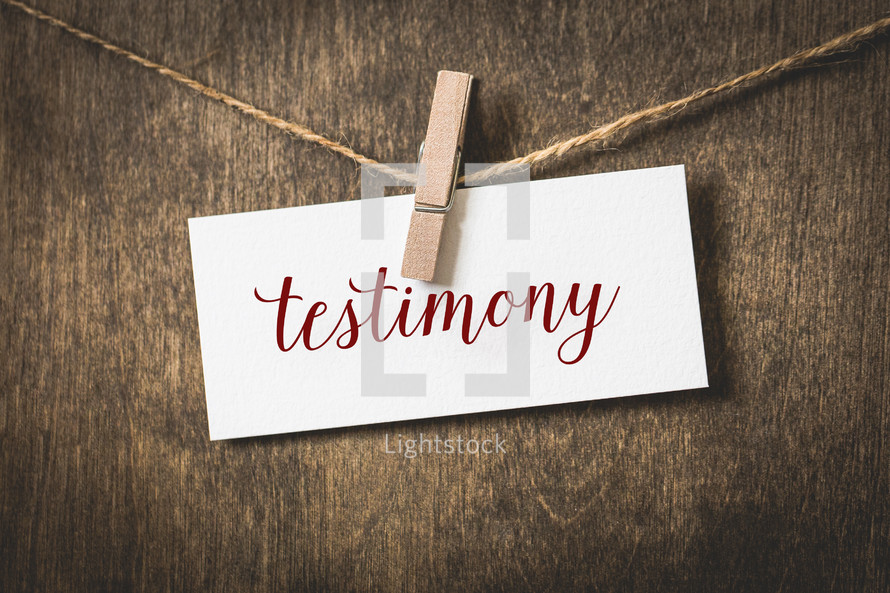 word testimony on white card stock hanging from a clothespin on a clothesline 
