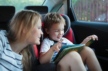 Mother and son with a book in the car
