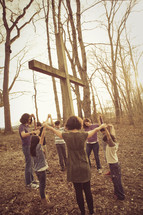 group holding hands in prayer around a cross