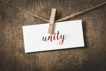word unity on white card stock hanging from a clothespin on a clothesline 