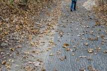a man walking down a path in fall 