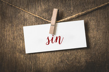 word sin on white card stock hanging from a clothespin on a clothesline 