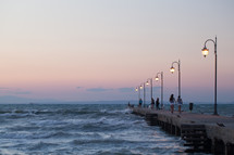 People walking along the pier in evening