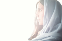 face of Mary in a blue shroud in bright light
