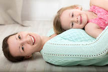 Smiling mother and daughter on the floor