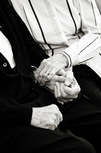 Grandparents holding hands and embracing.